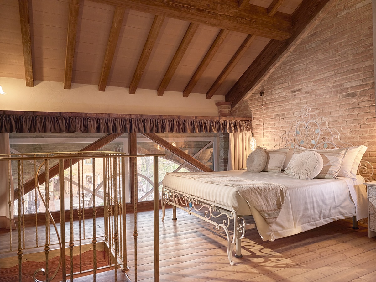 Luxurious bedroom with elegant decor and rustic beams at TM Relais, offering high-quality hospitality services.